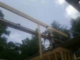 Carpenter setting a ridge beam over a new addition frame — Ice Dam Removal by Roofing Brothers in Moulton