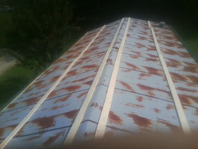 Rusted metal roof panels with new wood purlins before replacement — Storm Damage Roof Repair in Moulton by Roofing Brothers